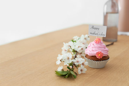 Tasty cupcake and flowers for Mother's Day on tableの写真素材
