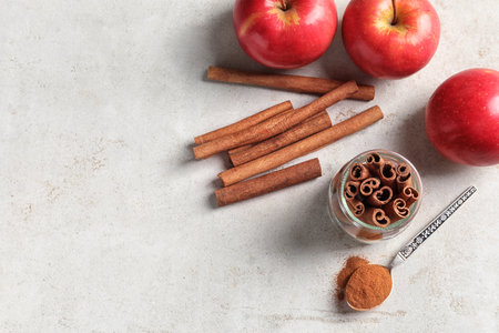 Fresh apples with cinnamon sticks and powder on table, top viewの写真素材