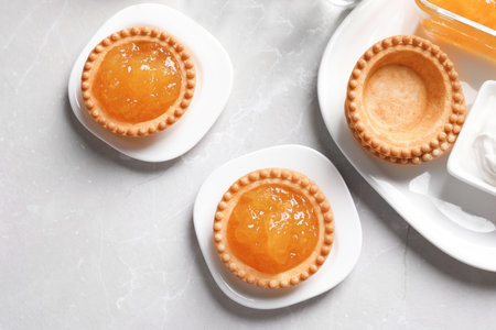 Tasty tartlets with jam on light background, top viewの写真素材