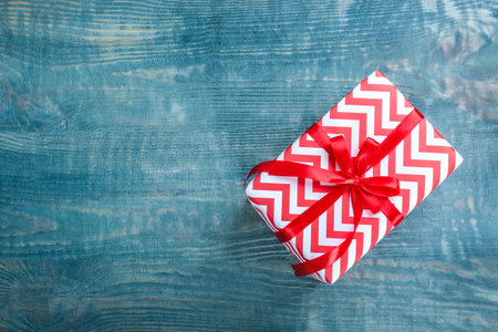 Elegant gift box with bow on wooden background, top viewの写真素材