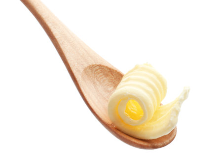 Wooden spoon with butter curl on white backgroundの写真素材