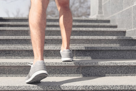 Sporty young man in training shoes outdoors, closeup