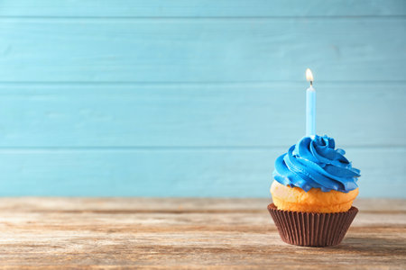 Delicious birthday cupcake with candle on tableの写真素材