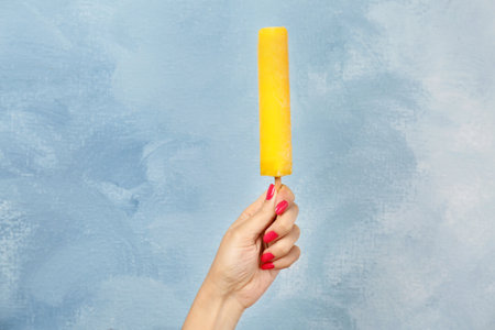Woman holding yummy ice cream on color background. focus on handの写真素材
