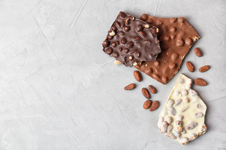 Different chocolate bars with nuts on gray background, top viewの写真素材