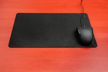 Blank mat and modern computer mouse on color background
