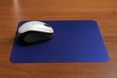 Blank pad and wireless computer mouse on wooden backgroundの写真素材