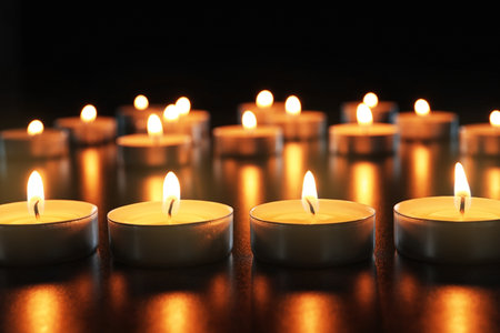 Wax candles burning on table in darkness, closeupの写真素材