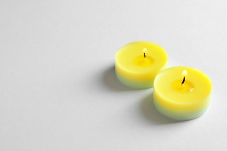 Colorful wax candles burning on white backgroundの写真素材