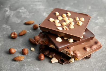 Delicious milk and dark chocolate bars with nuts on table