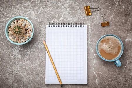Flat lay composition with notebook and cup of coffee on gray backgroundの写真素材