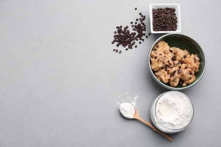 Flat lay composition with cookie dough, chocolate chips and flour on gray backgroundの写真素材