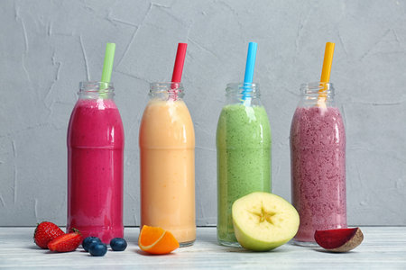 Bottles with healthy detox smoothies and ingredients on tableの写真素材