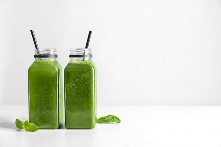 Bottles with delicious detox juice on light backgroundの写真素材