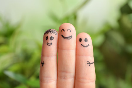 Fingers with drawings of happy faces against blurred background. unity conceptの写真素材