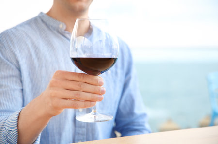 Young man with glass of red wine outdoorsの写真素材