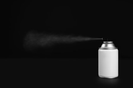 Woman spraying air freshener on black background, closeupの写真素材