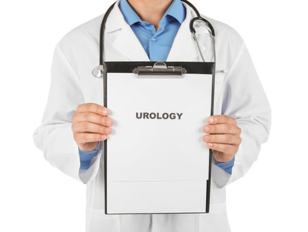 Male doctor holding clipboard with word UROLOGY on white backgroundの写真素材