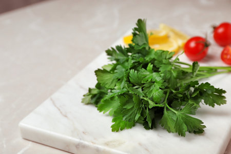 Stone board with fresh green parsley on table, closeupの写真素材