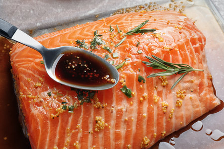 Spoon with marinade on raw salmon fillet, closeupの写真素材