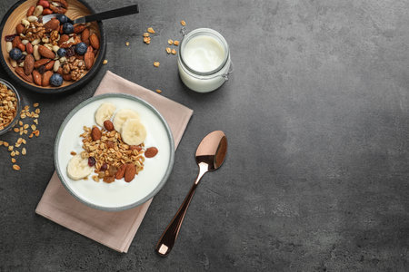 Tasty yogurt with banana and granola for breakfast on table, top viewの写真素材