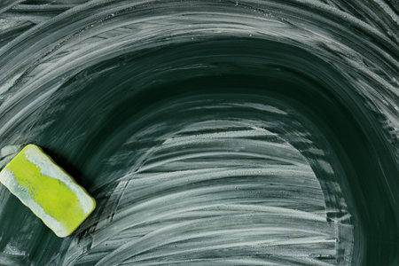 Dirty chalkboard with duster, closeup. school equipmentの写真素材