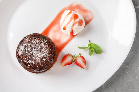 Delicious fresh fondant with hot chocolate, ice cream and strawberry served on plate, top view. Lava cake recipeの写真素材