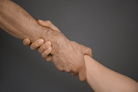 Men holding hands together on gray background. unity conceptの写真素材