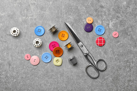 Composition with threads and sewing accessories on gray background, top view