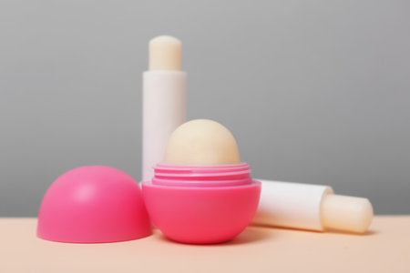 Hygienic lipsticks and balms on table against gray backgroundの写真素材