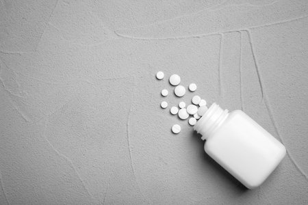 Container with pills on gray background, flat layの写真素材
