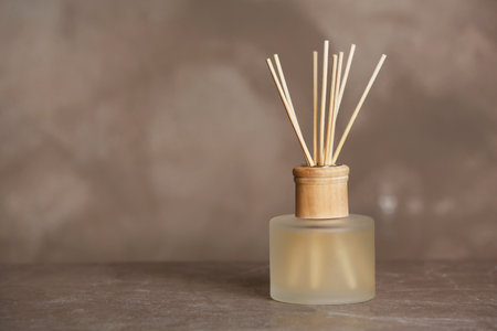 Aromatic reed freshener on table against gray background