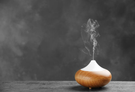 Aroma oil diffuser on table against gray background. air freshenerの写真素材