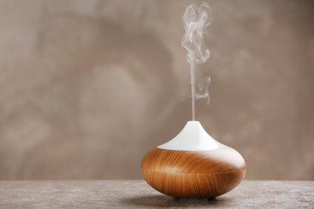 Aroma oil diffuser on table against gray background. air freshener