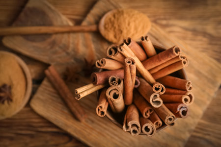 Bowl with aromatic cinnamon sticks on wooden backgroundの写真素材