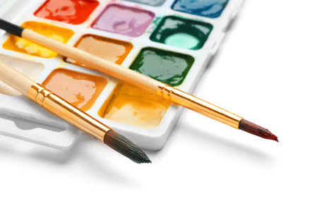 Brushes and plastic palette with colorful paints on white backgroundの写真素材