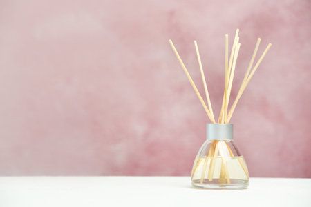 Aromatic reed freshener on table against color backgroundの写真素材