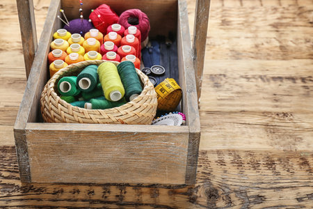 Box with color sewing threads on wooden backgroundの写真素材