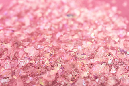 Pieces of shiny rose material on fabric, closeupの写真素材