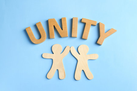 Wooden people giving high five and word UNITY on color background. unity conceptの写真素材