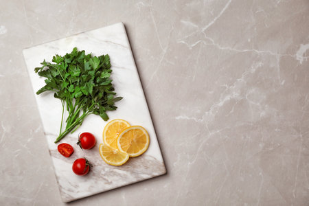 Flat lay composition with fresh parsley, cherry tomatoes and lemon on gray backgroundの写真素材