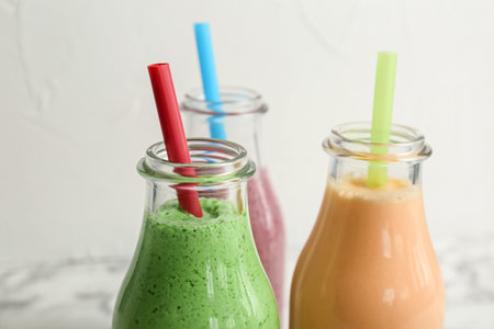 Bottles with healthy detox smoothies on light background, closeupの写真素材