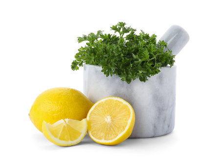 Mortar with green fresh parsley and lemons on white backgroundの写真素材