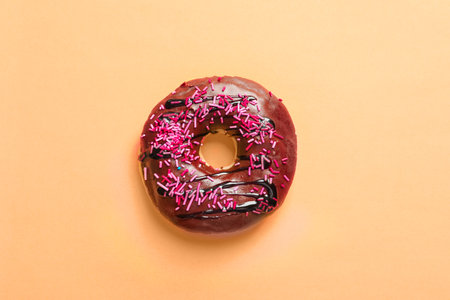 Delicious glazed donut with sprinkles on color background, top viewの写真素材