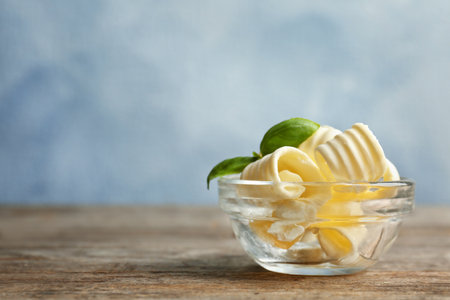 Bowl with tasty butter curls on tableの写真素材