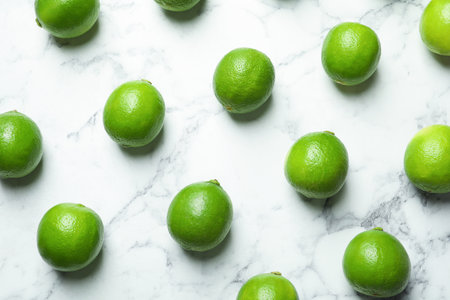 Fresh ripe green limes on marble backgroundの写真素材