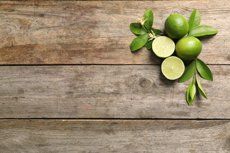 Composition with fresh ripe limes on wooden background, top viewの写真素材