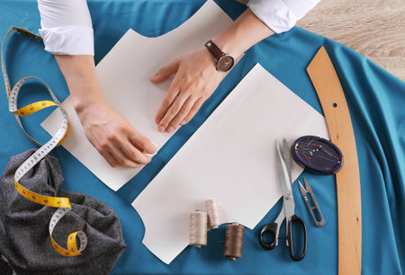 Tailor working at table in atelier, top viewの写真素材