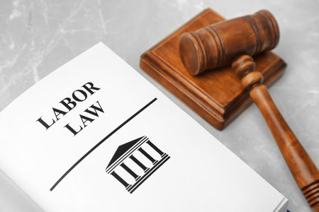Open book with words LABOR LAW and gavel on table, closeupの写真素材