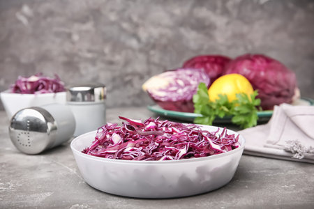 Bowl with chopped purple cabbage on tableの写真素材
